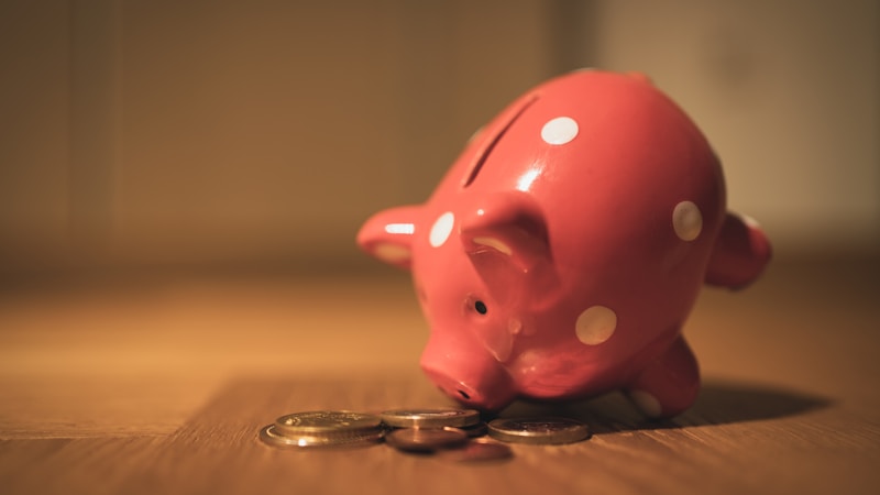 Pink piggy bank surrounded by coins, representing saving money during no-spend challenges
